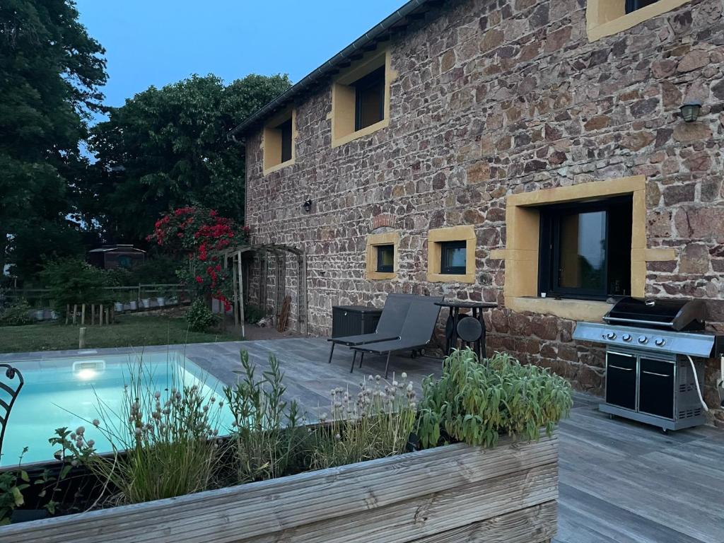 Commelle-VernayLa Grange aux hirondelles - appartement complet et indépendant的石头房子,设有游泳池和庭院