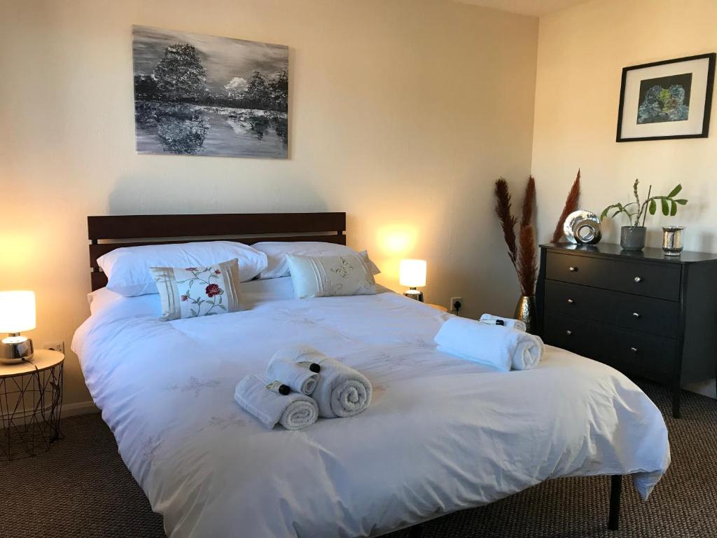瑟斯克Lavender Cottage的卧室配有带毛巾的大型白色床