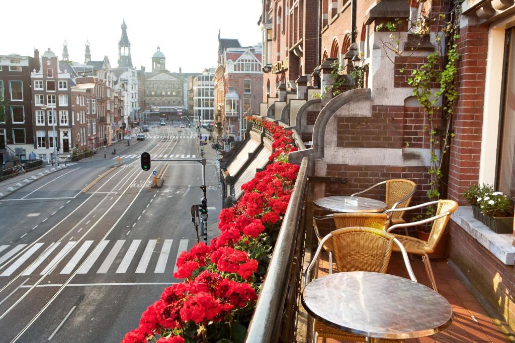 阿姆斯特丹Di-Ann City Centre Hotel的城市街道上带桌子和鲜花的阳台