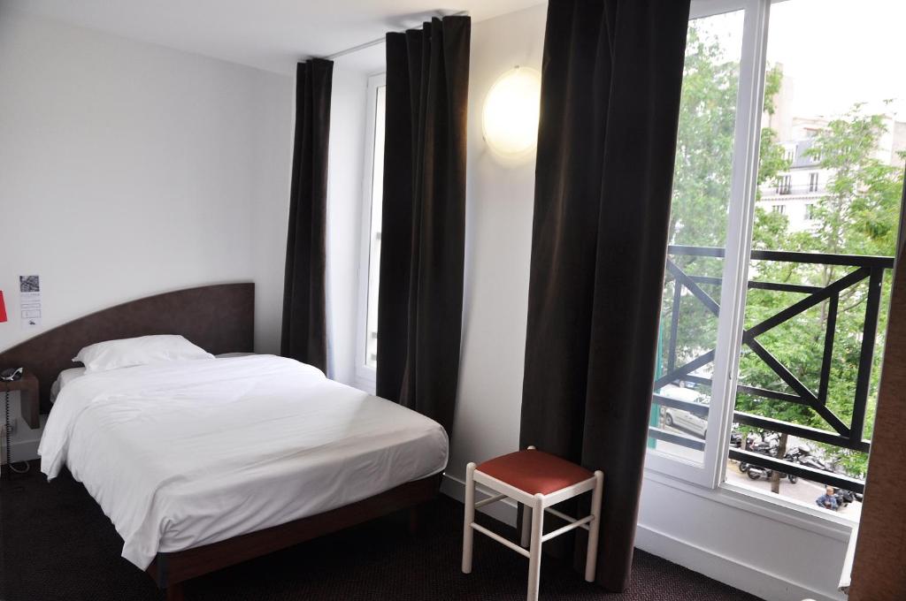 巴黎德拉图尔酒店 的一间卧室设有一张床和一个大窗户