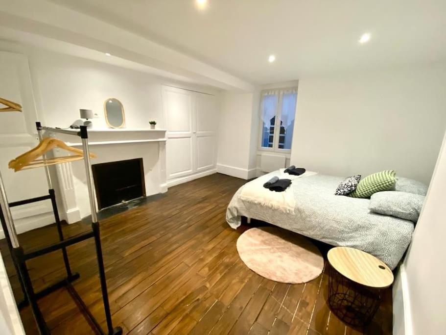 奥布河畔巴尔Maison individuelle atypique sur 2 étages的客厅设有一张床和一个壁炉