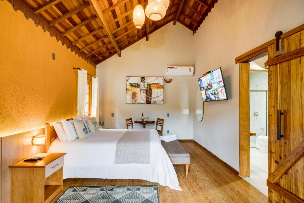 蒙特韦尔迪Pousada Jardim Monte Verde的一间卧室配有一张大床和一张桌子