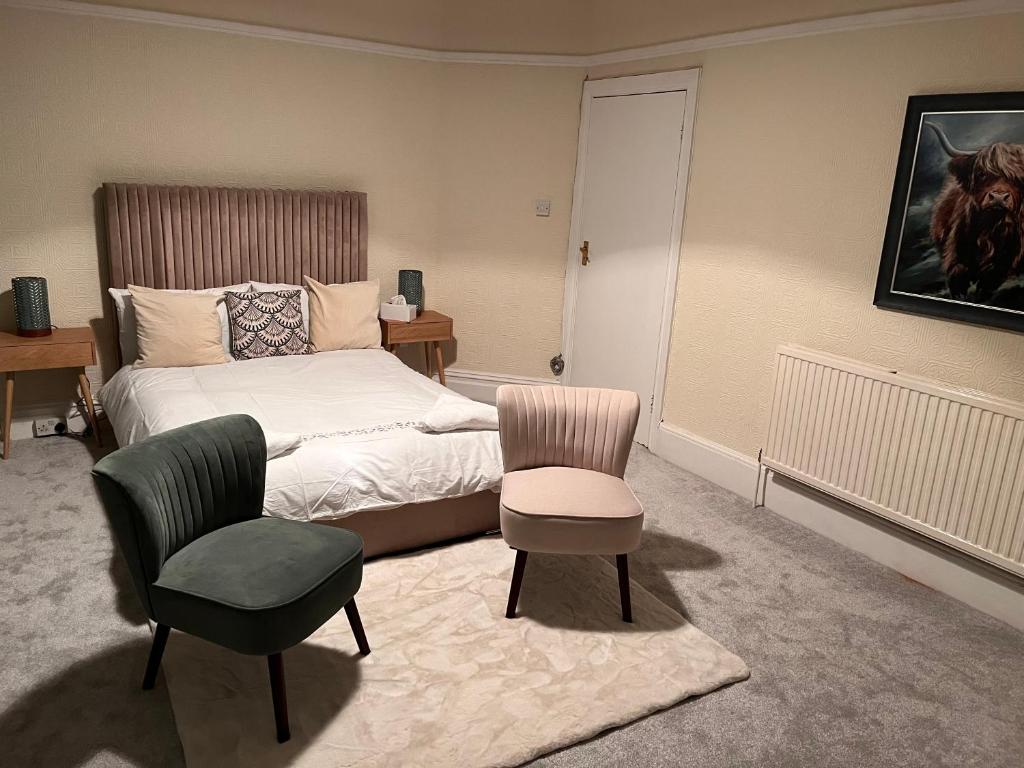 伦敦Luxury Cosy Retreat Apt的一间卧室配有一张床、一把椅子和一张桌子