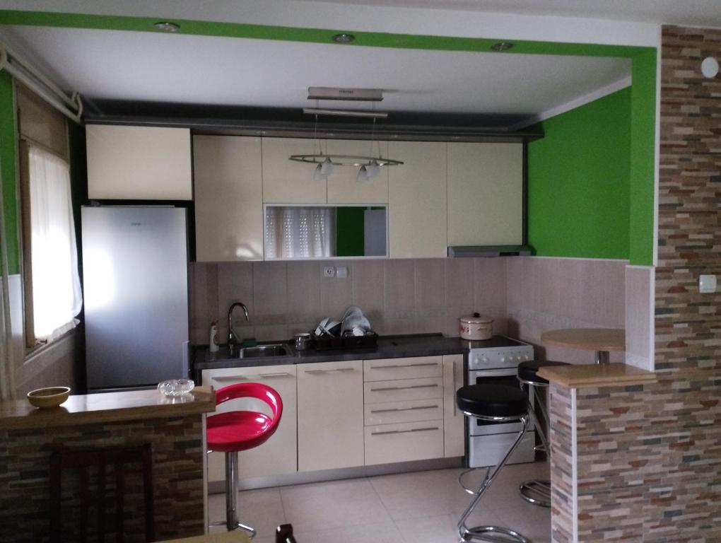 BrusVila Mihajlovic的厨房配有白色橱柜和绿色墙壁