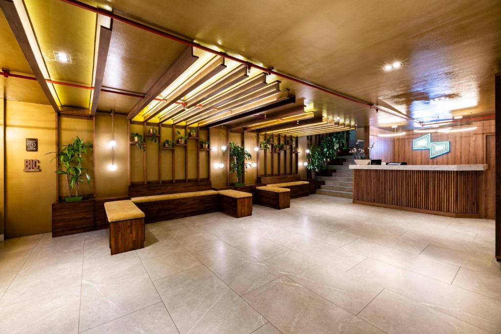 波哥大Hotel Vilar América的大厅,里面摆放着长凳和盆栽植物