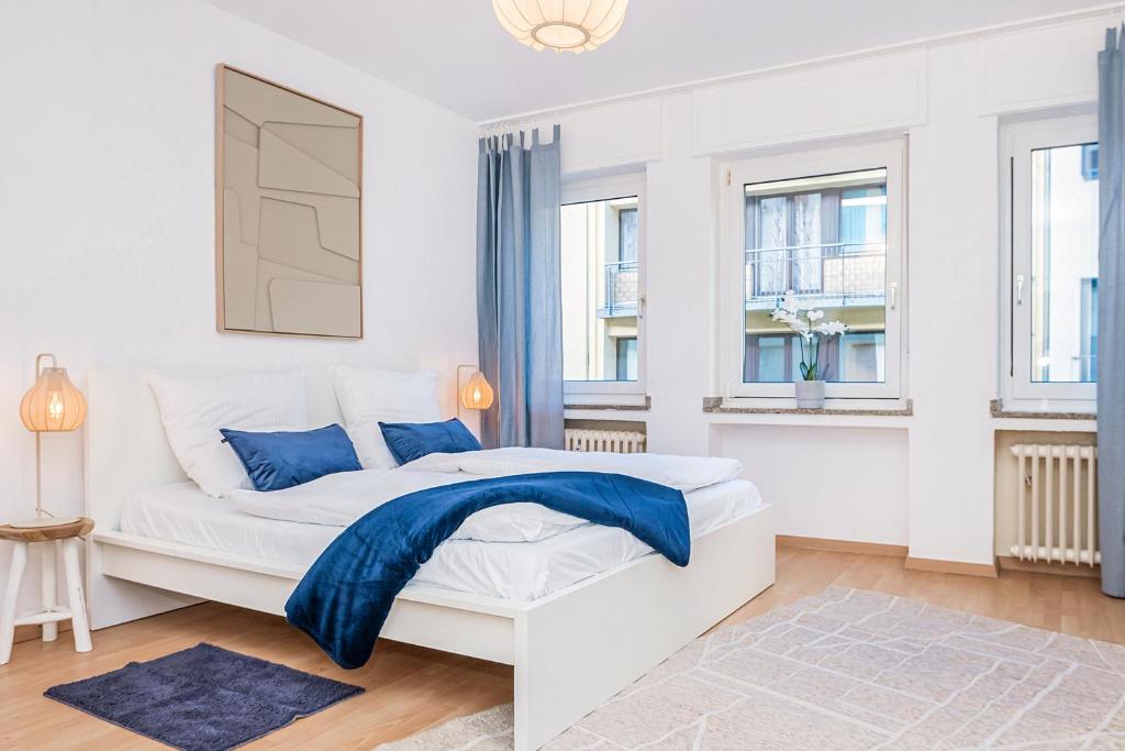 克雷费尔德Center Terrace Dream Apartment的一间白色卧室,床上铺有蓝色毯子