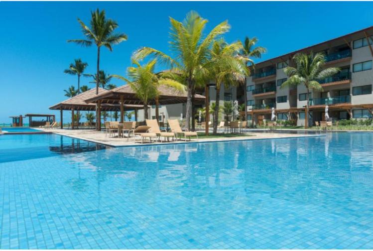嘎林海斯港Polinésia Resort - Luxuoso Beira Mar Muro Alto - Porto de Galinhas - ANunes的一座棕榈树大型游泳池