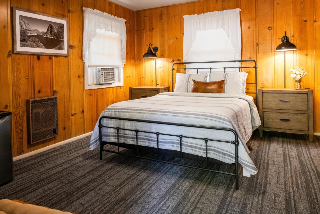 格罗夫兰Inn at Sugar Pine Ranch的一间卧室配有一张床,并在一间客房内配有电视。