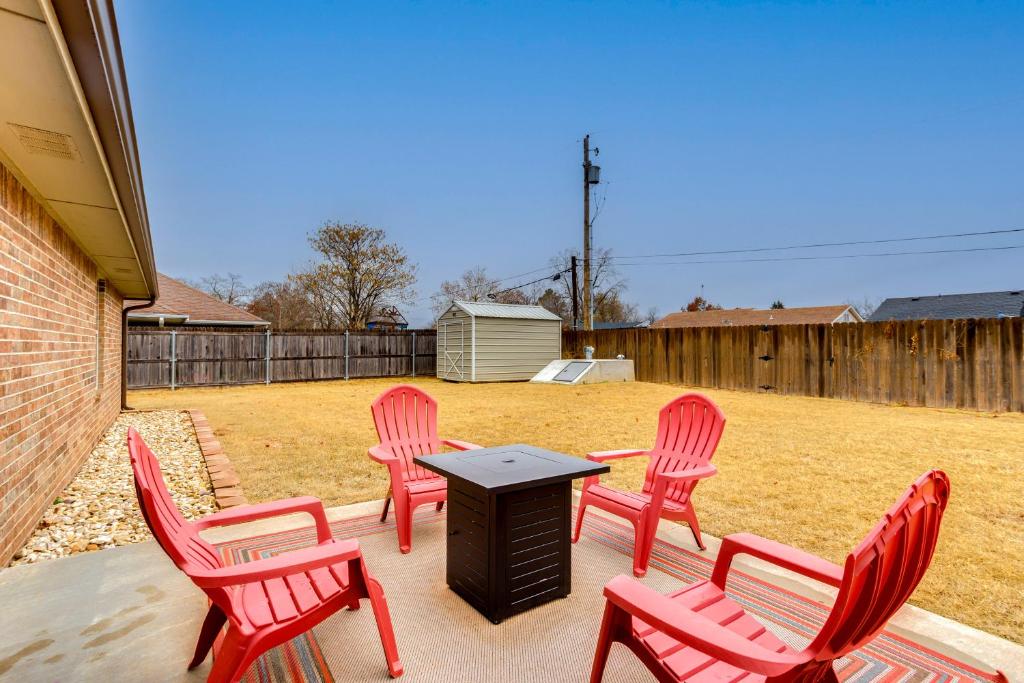 ChandlerChandler House with Fenced Backyard Pets Welcome!的庭院里一组红色的椅子和一张桌子