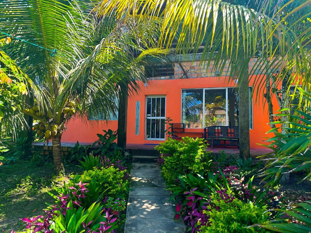 伊基托斯Otorongo Guest House的一座橘色房子,前面有一棵棕榈树