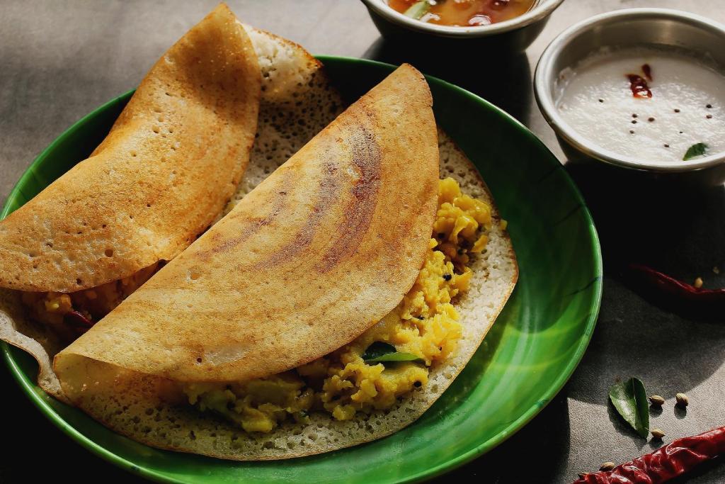 班加罗尔OYO Sai Ram Residency的两片含双皮塔面包和浸泡的绿色食物