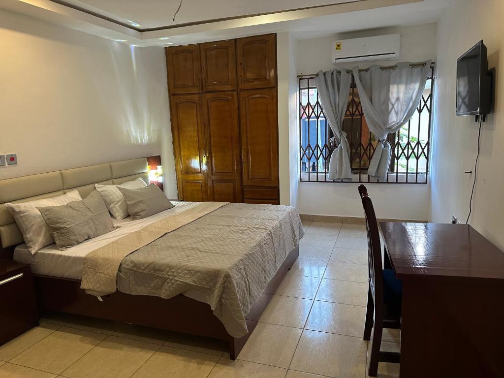 库马西D Barfi Guesthouse, excellent location的卧室配有床、桌子和窗户。