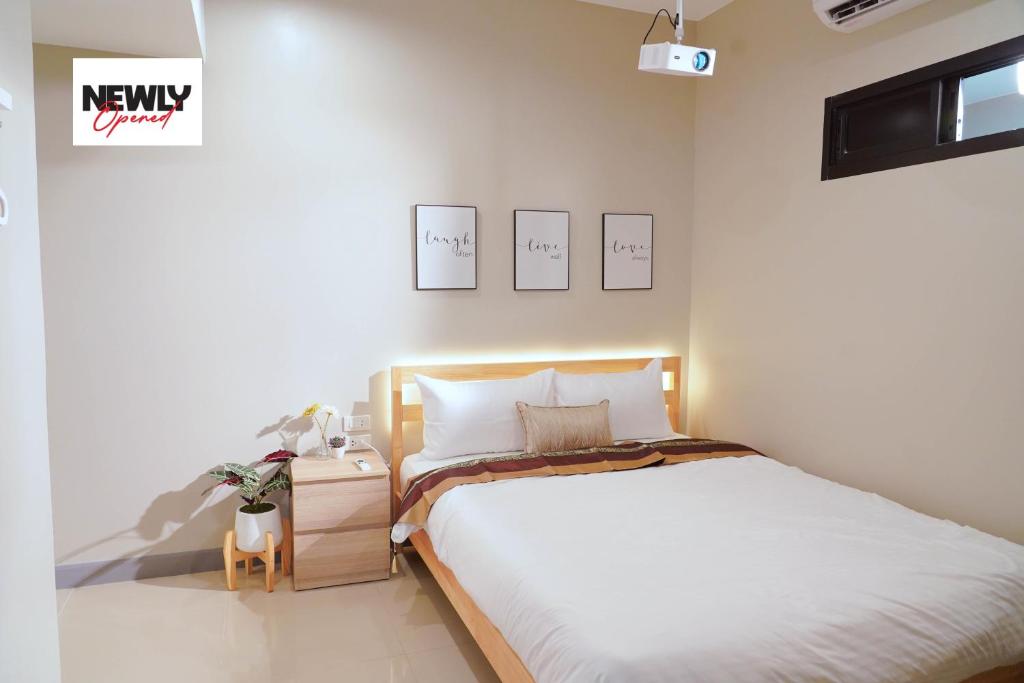 曼谷BnB98 Silom Hotel - 1 minutes from SKY TRAIN Sala Daeng station and SUBWAY Silom station的一间卧室配有一张大床和一个带四柱床的床头柜。