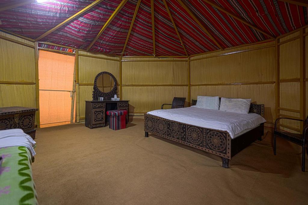 Al WāşilSAFARI-Glamping的一间帐篷内带一张床和镜子的房间