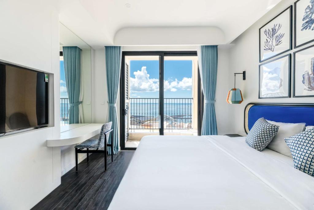 富国Rosie Hillside Seaview Phu Quoc Apartment的酒店客房设有一张大床和一个阳台。