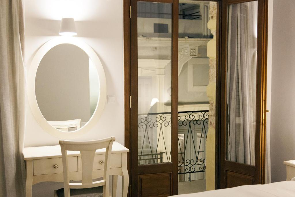 干尼亚Shalom Luxury Rooms Kondilaki的一间设有镜子、一张桌子和一把椅子的房间