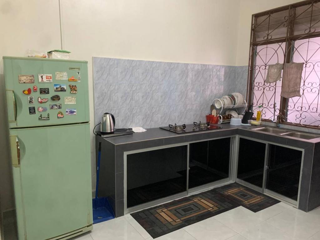 Rantau PanjangZahra Homestay的厨房配有柜台和冰箱。