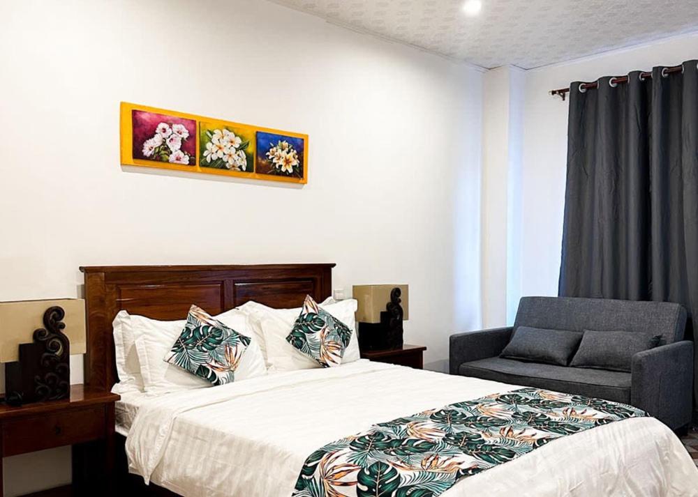 维拉港Crown Royale Hotel & Lounge的一间卧室配有一张床和一把椅子