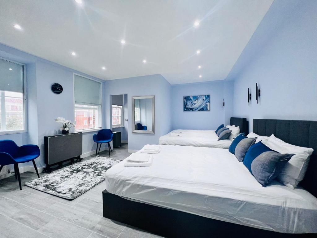伦敦Hyde Park Studio Flats的一间卧室设有两张床,拥有蓝色的墙壁。