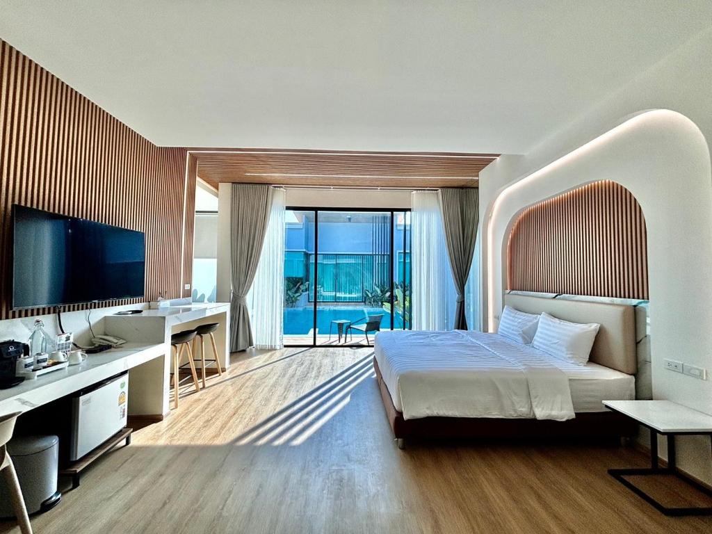 拉差汶里Rock Resort Ratchaburi的一间卧室配有一张床、一张书桌和一台电视