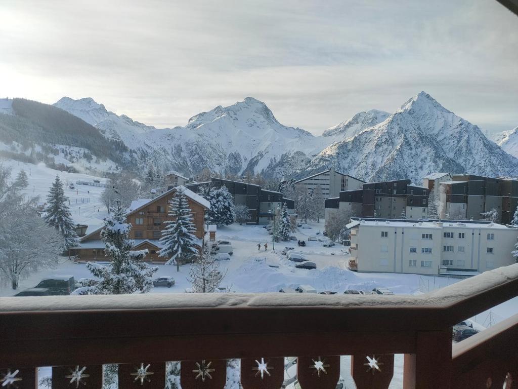 莱德萨阿尔卑斯résidence Plein Sud à côté Jandri express, front de neige, vue splendide, Label 2 Alpes, classé 2 étoiles Tourisme的享有带雪覆盖山脉的小镇美景。
