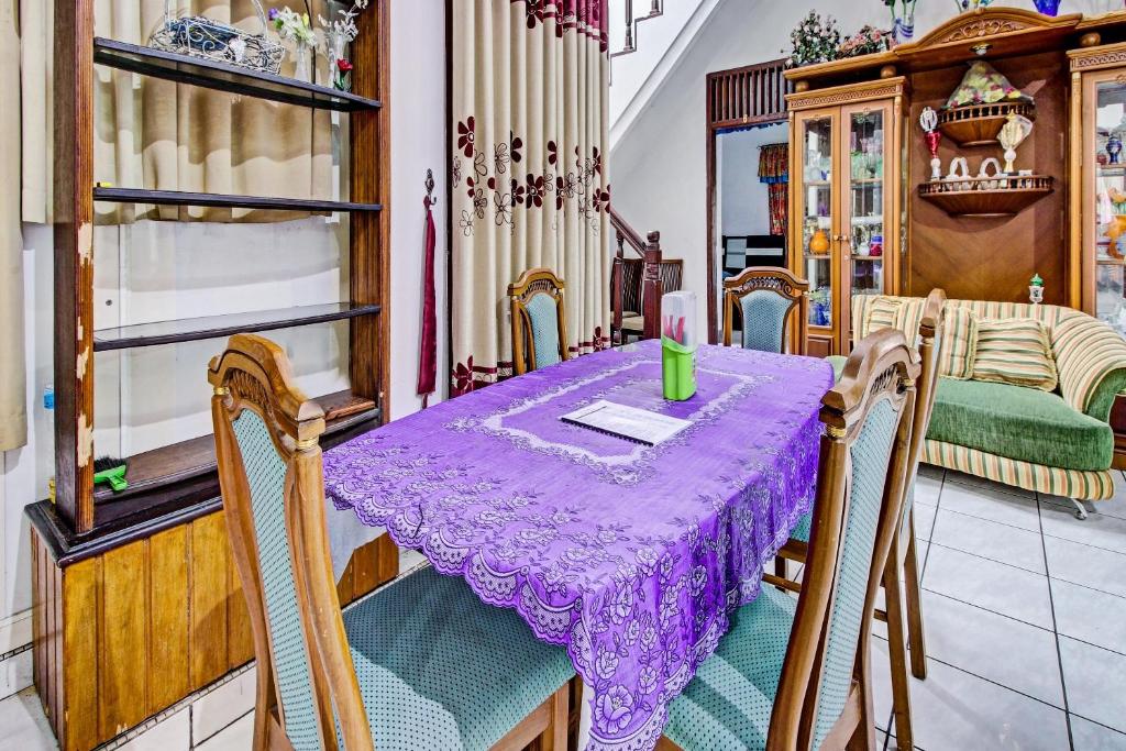 库宁岸OYO 90543 An-nur Guest House Syariah的一张桌子,房间里有一个紫色的桌布