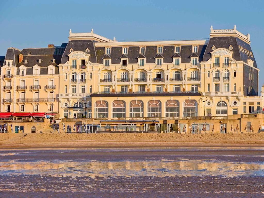 卡布尔Le Grand Hotel de Cabourg - MGallery Hotel Collection的海边的一座大建筑