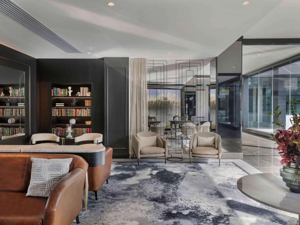 奥克兰索菲特奥克兰高架桥港酒店的客厅配有沙发和桌椅
