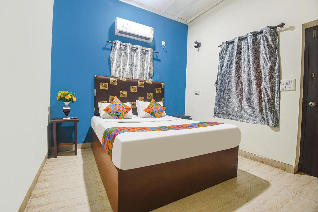 巴加FabHotel IRAA Resort With Pool的一间卧室配有一张蓝色墙壁的床