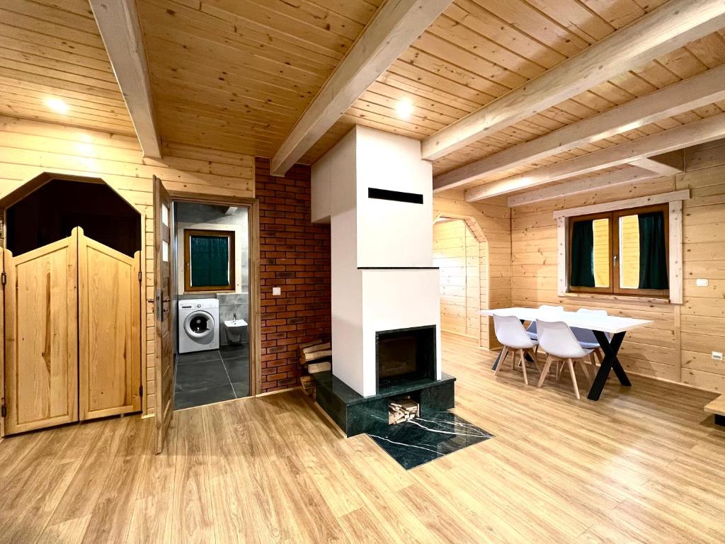 KamesznicaHighlander - drewniany dom w Beskidach的一间房屋内带壁炉和桌子的房间