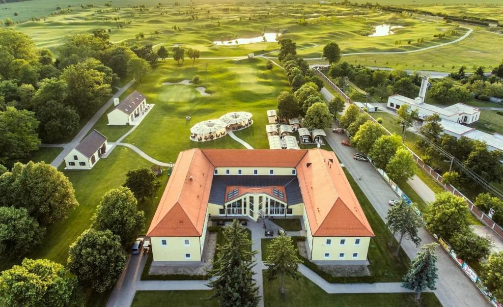 BáčKlaudia's Hotel & Restaurant at Golf Resort, Bač Šamorín的享有带高尔夫球场的房屋的空中景致