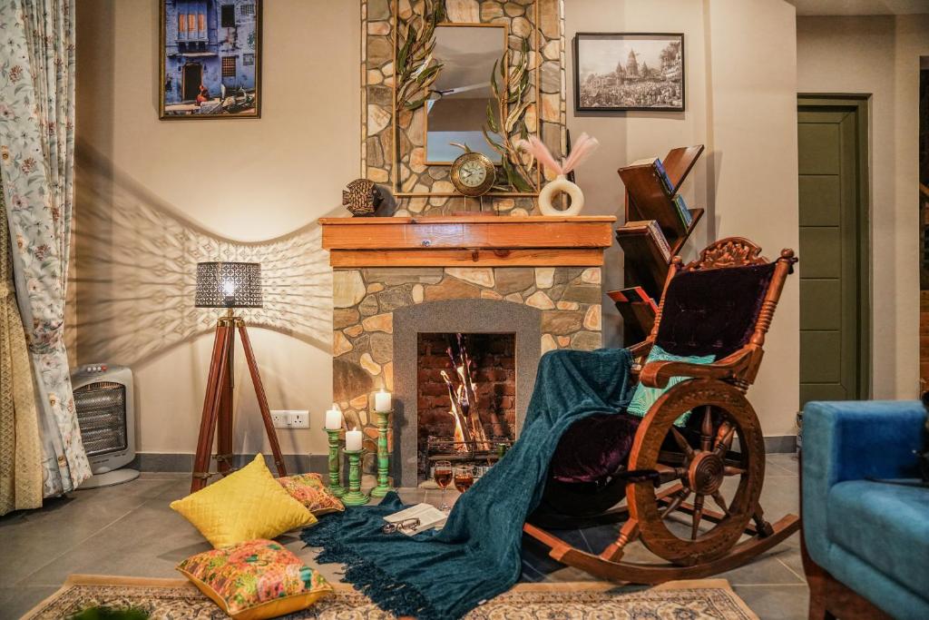拉尼凯特SaffronStays Edelweiss Estate的客厅在壁炉前配有摇椅
