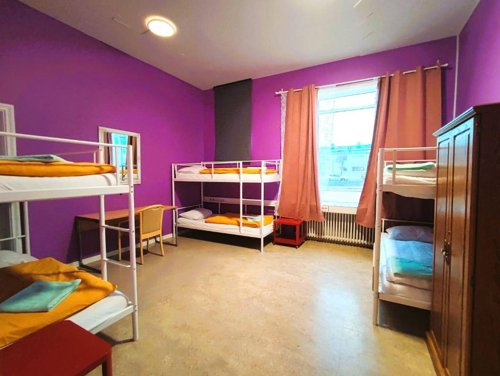 雷克雅未克Hostel B47的一间设有三张双层床和紫色墙壁的客房