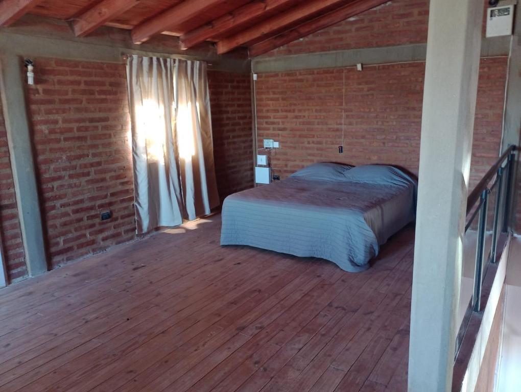 岑特纳里奥Casagrande Centenario的一间卧室,在木甲板上配有一张床