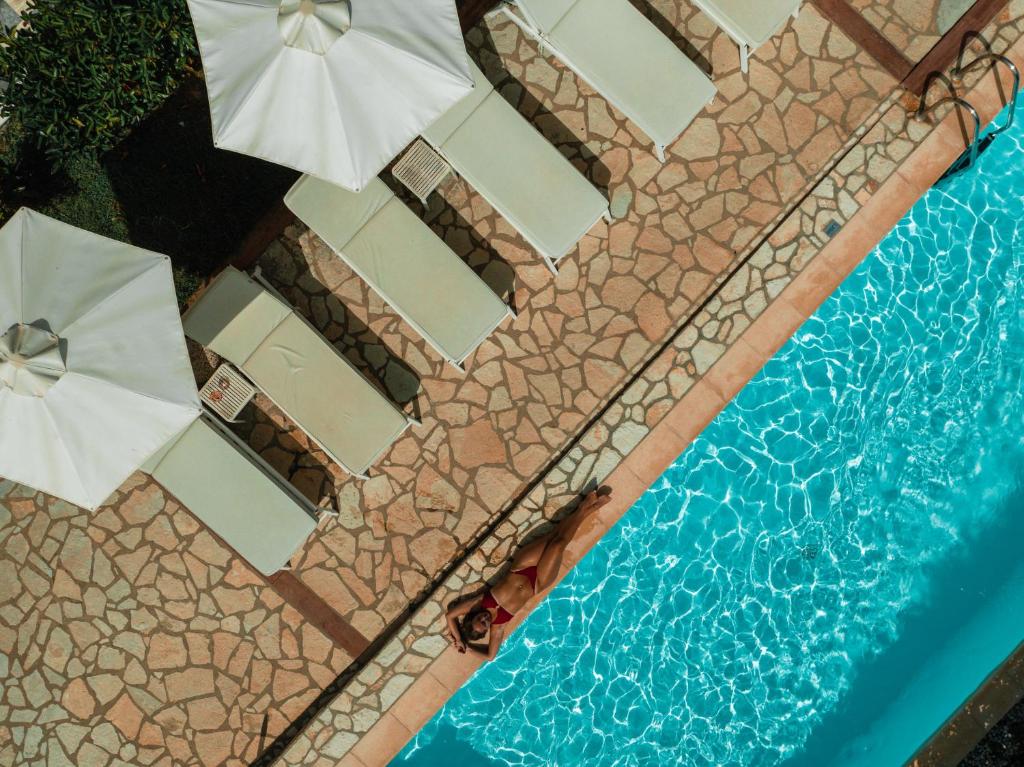 帕尔加Dracos Hotel的享有带遮阳伞的游泳池的顶部景致