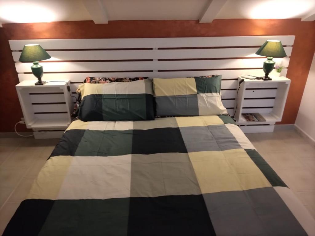 圣埃拉莫因科莱B&b La Camelia的一间卧室配有一张带2个床头柜和2盏灯的床。