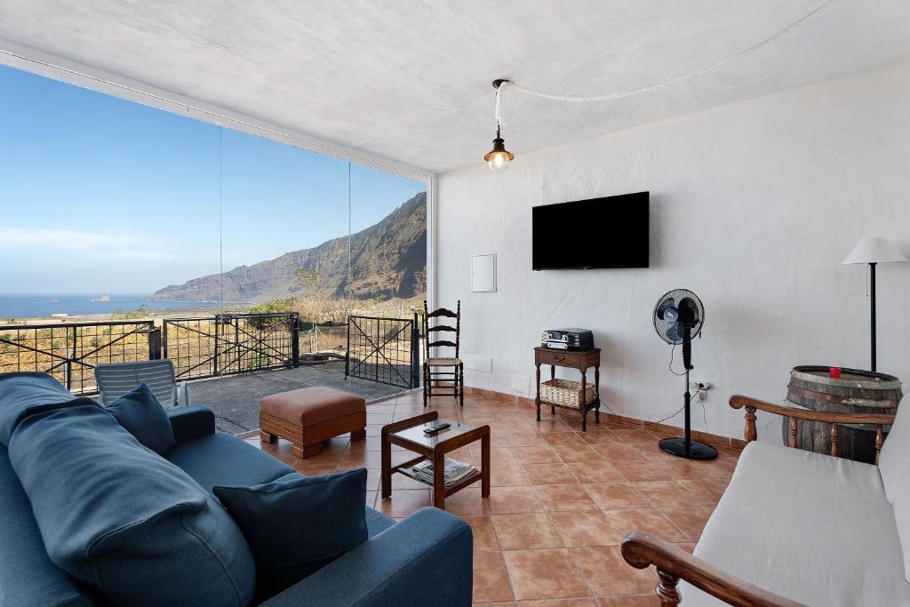 弗龙特拉La Cuadra de Juan的客厅设有蓝色的沙发和大窗户