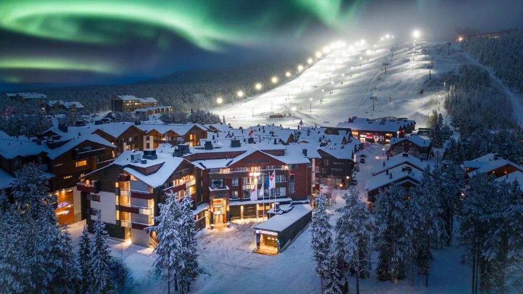 列维利瓦伊布瑞克索克斯酒店的夜间雪地中的一个度假村,有北极光