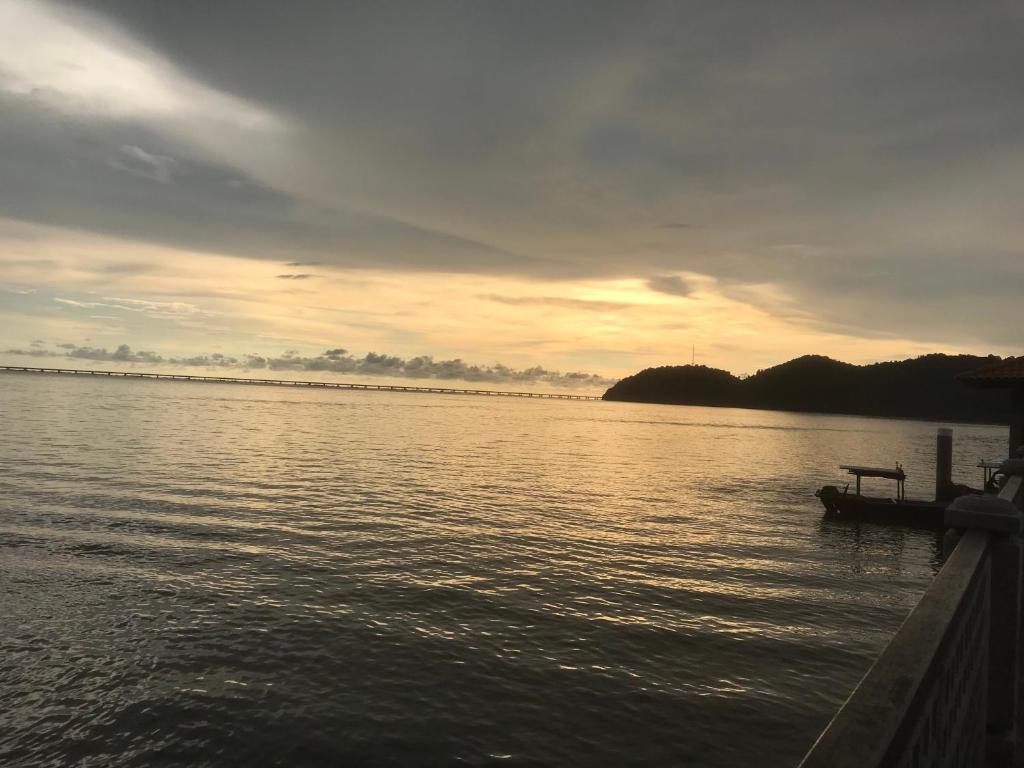 新邦安拨Batu Kawan HS的水面上的船,背面有日落