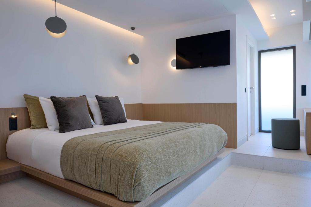 比雷埃夫斯Twinn Downtown Piraeus的一间卧室配有一张大床和一台平面电视