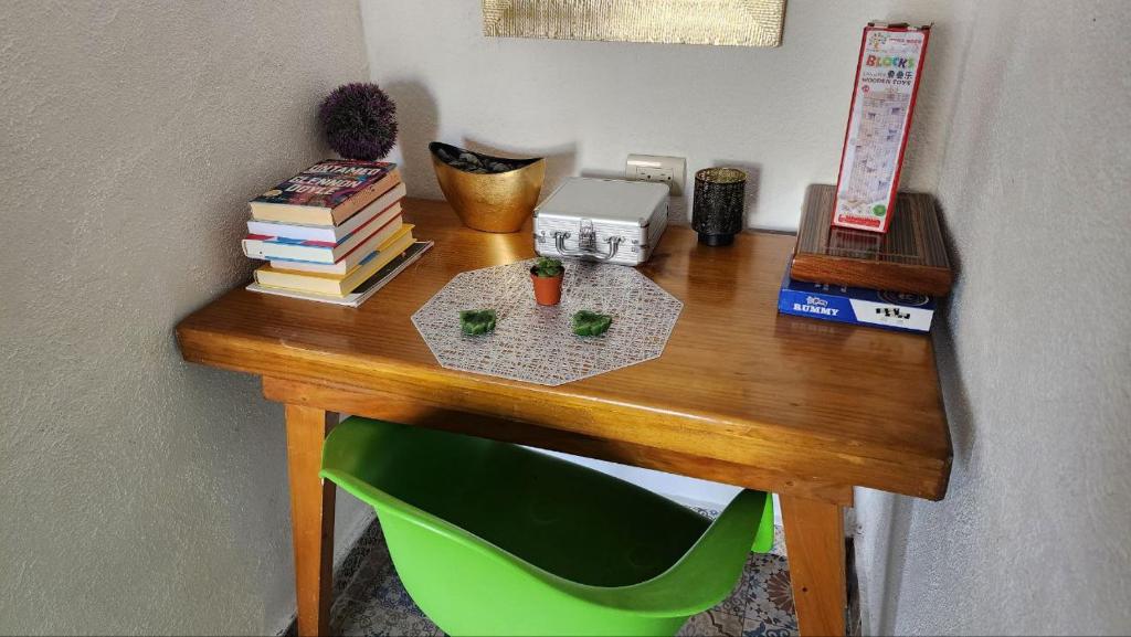 圣佩德罗拉拉古纳VENICE by luxury Atitlan的一张带书籍和绿色椅子的木桌