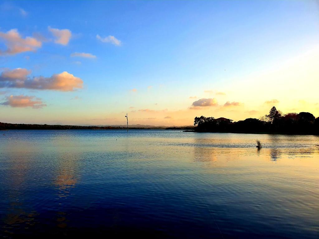 ArenosaCabana's on Gatun Lake in Arenosa的日落时分在水中与人同在的湖泊