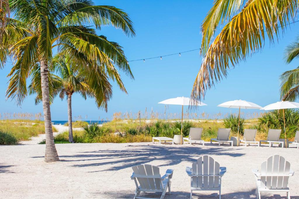 圣徒皮特海滩莫洛伊海湾小屋汽车旅馆的海滩上一群椅子和棕榈树