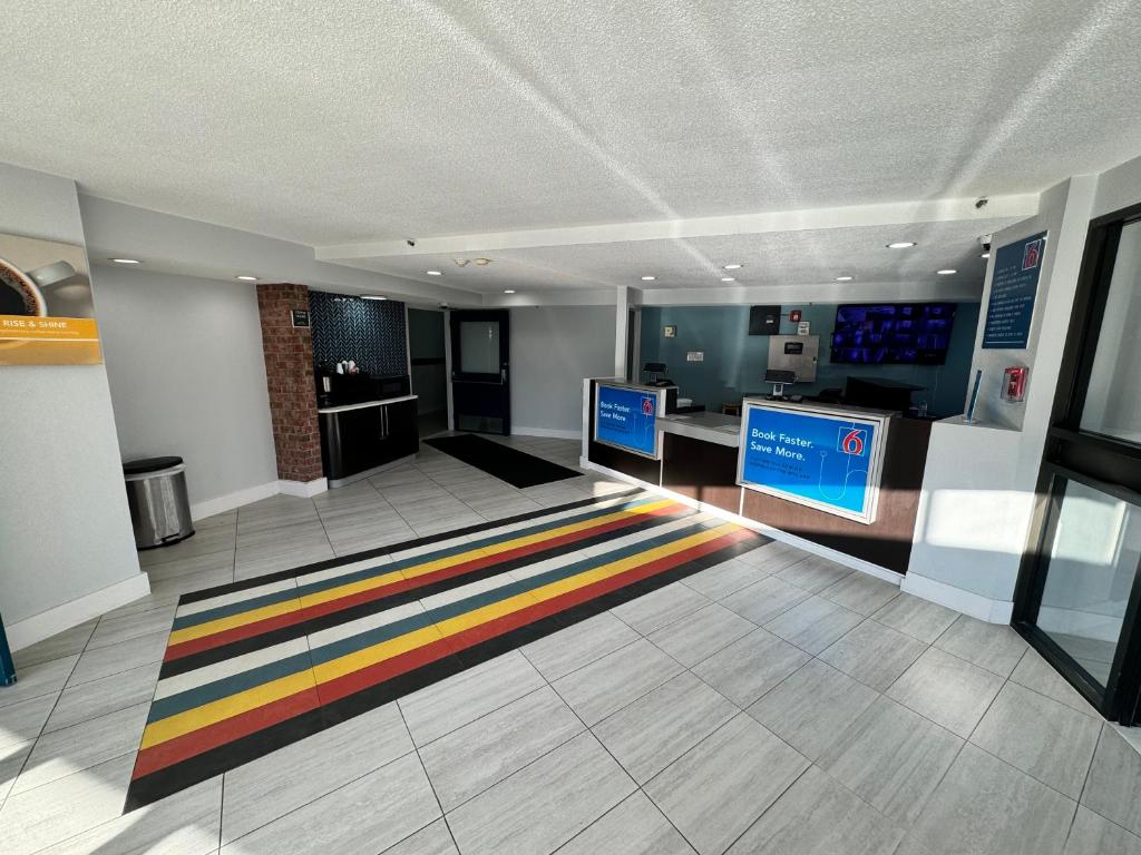 东叙拉古Studio 6 Suites East Syracuse NY Airport的一间大房间,地板上铺着色彩缤纷的地毯
