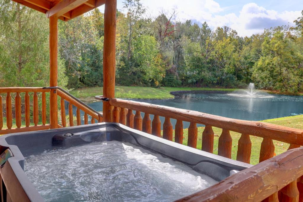 米勒斯堡Waterview Lodge by Amish Country Lodging的一个带池塘的甲板上的热水浴池