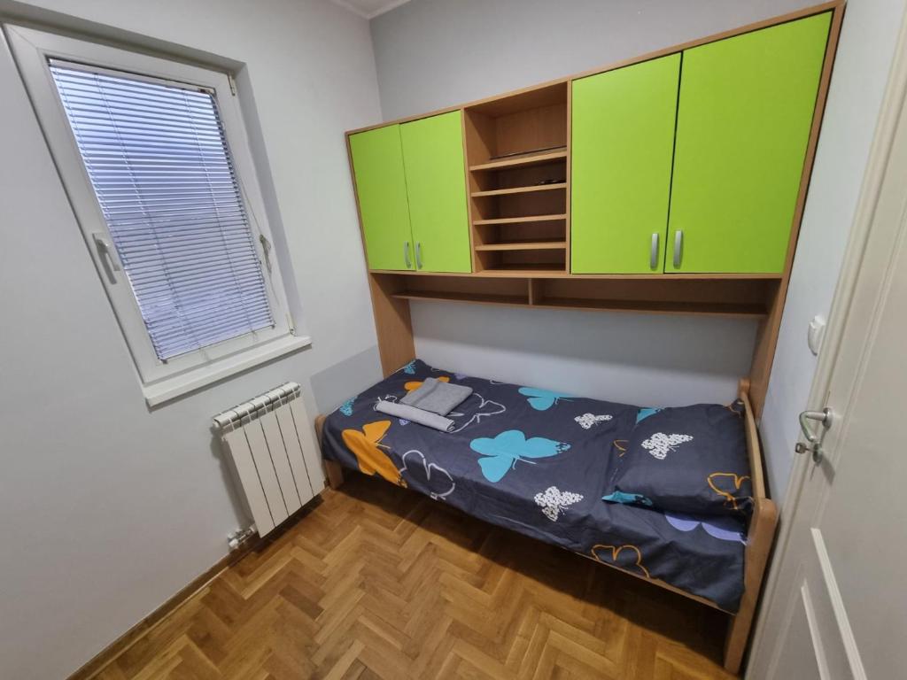 贝尔格莱德Malina的小房间设有绿色橱柜和一张床