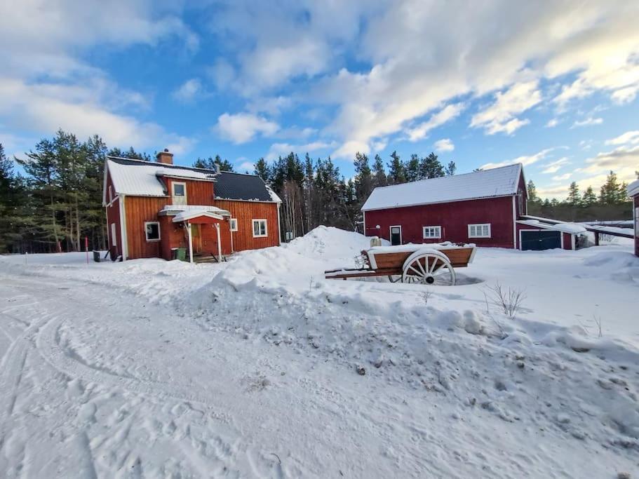 LillhärdalFerienhaus am Waldrand的雪中的一个红谷仓,靠近一条道路