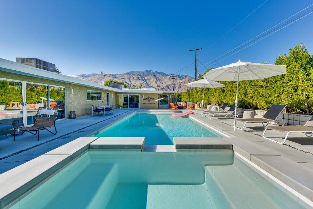 棕榈泉Luxe Palm Springs Home - Close to Downtown!的一个带椅子和遮阳伞的游泳池