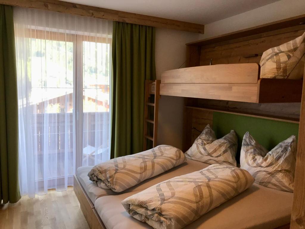 阿尔卑巴赫Ferienwohnung Neubau的一间卧室设有两张双层床和一扇窗户。