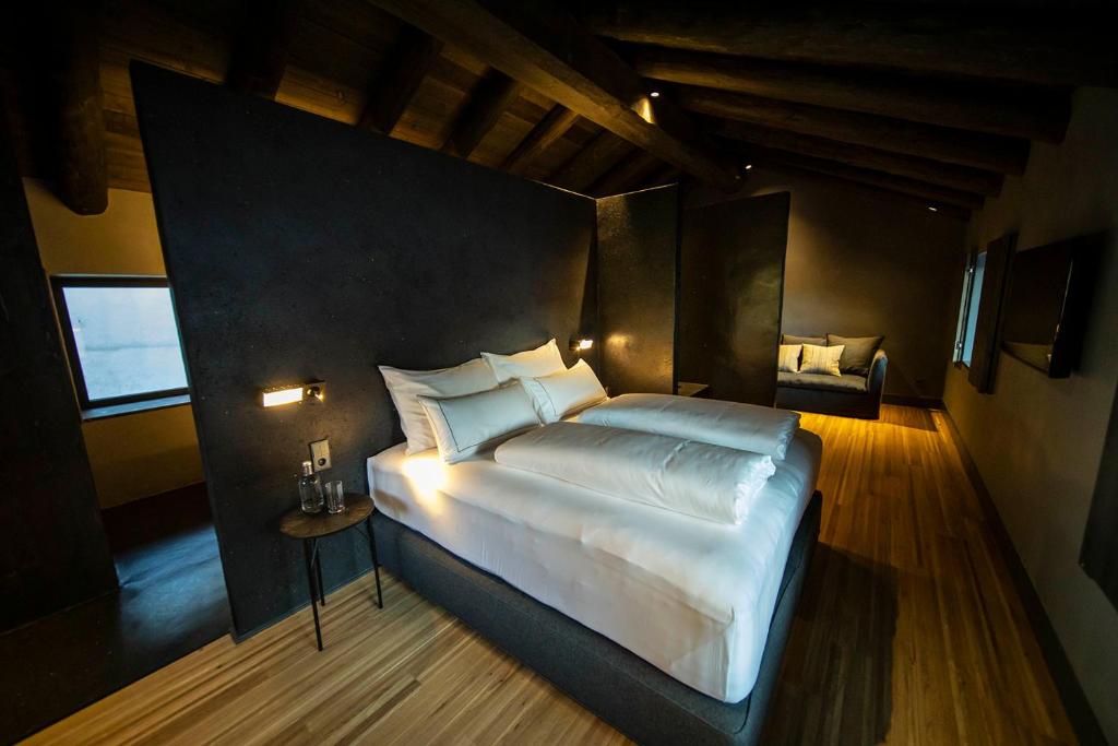 恩坎普Les Pardines 1819 Mountain suites & SPA的卧室配有一张白色大床